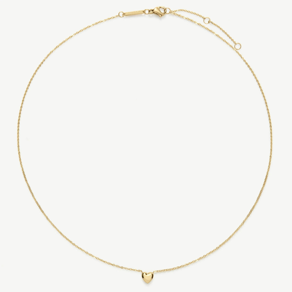 Delicate gold chain necklace with a small heart pendant on a white background