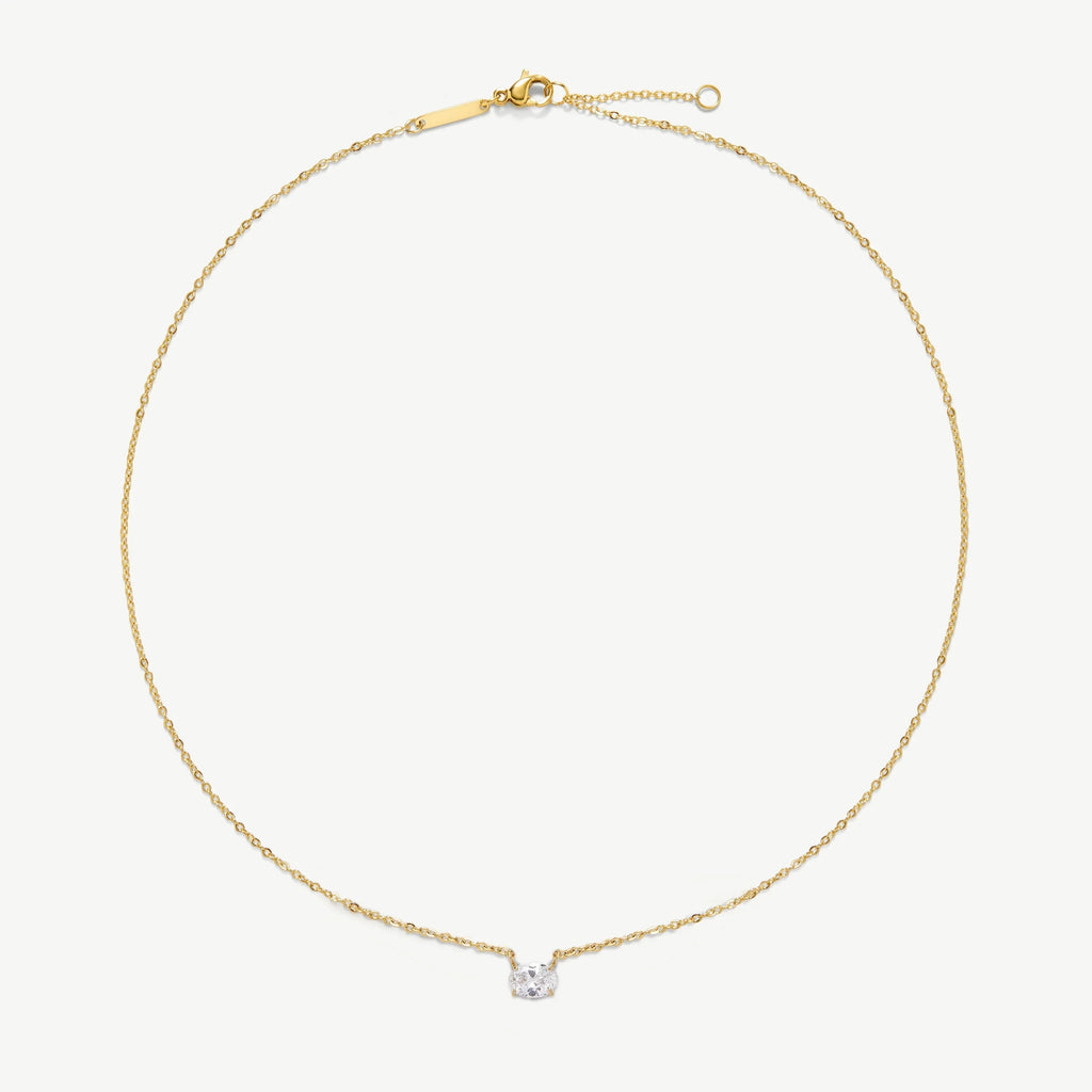 Delicate gold chain necklace with a small clear gemstone pendant on white background