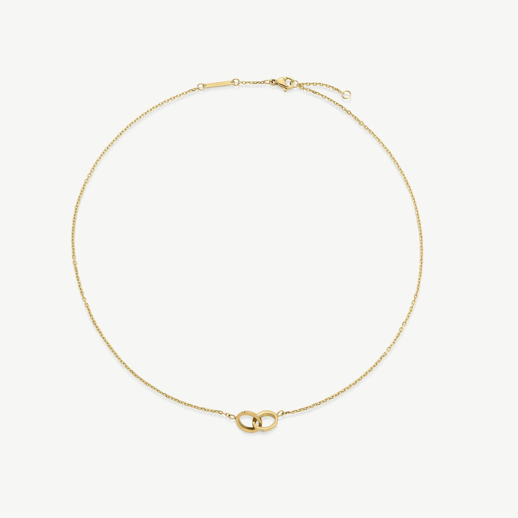 Delicate gold chain necklace with interlocking ring pendant on white background