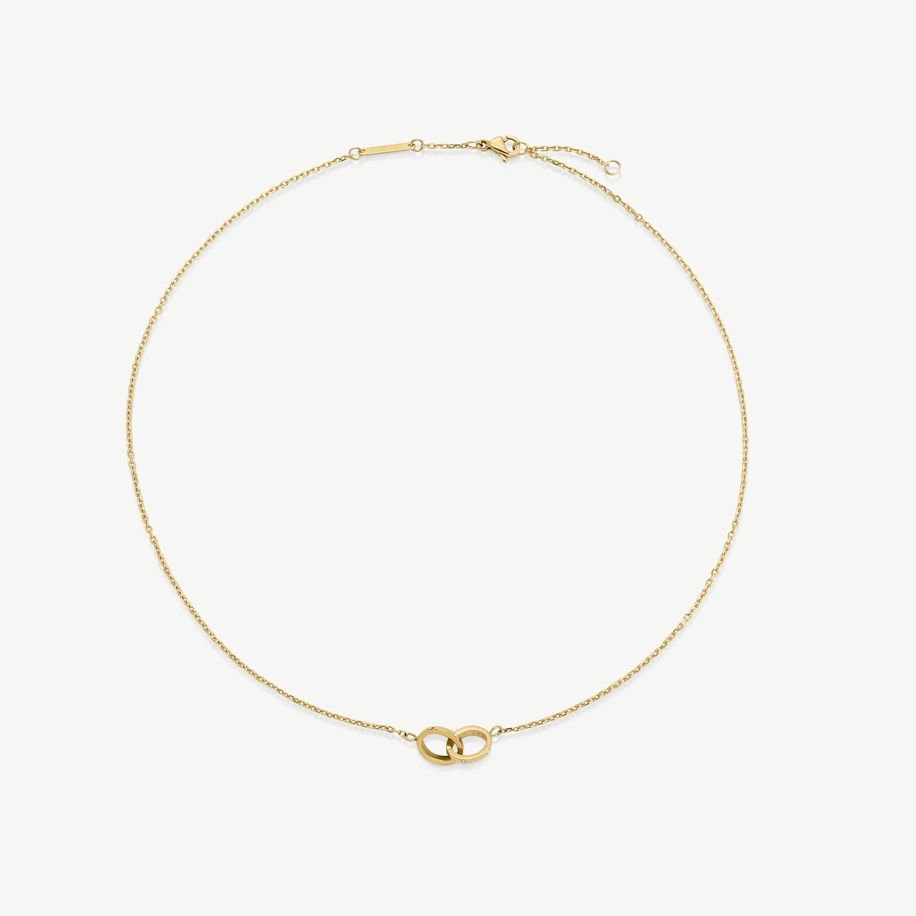 Delicate gold chain necklace with interlocking ring pendant on white background