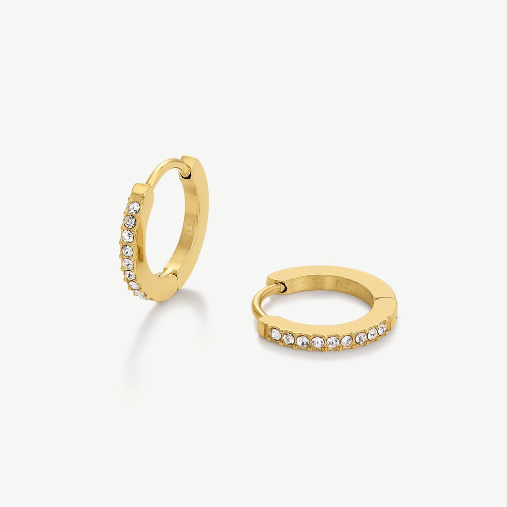 Pair of gold hoop earrings adorned with small clear crystals on white background