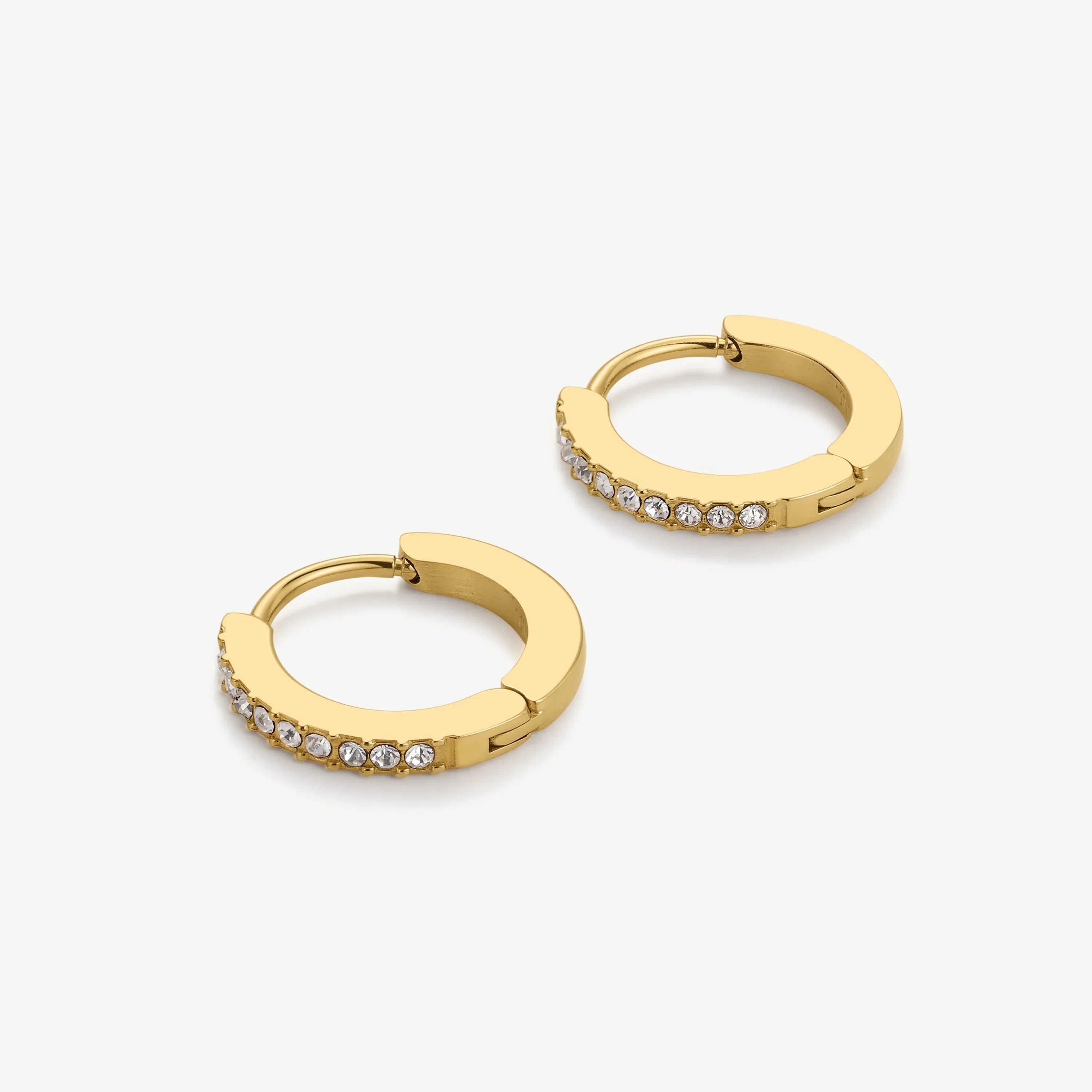 Pair of gold hoop earrings with clear rhinestone accents on white background