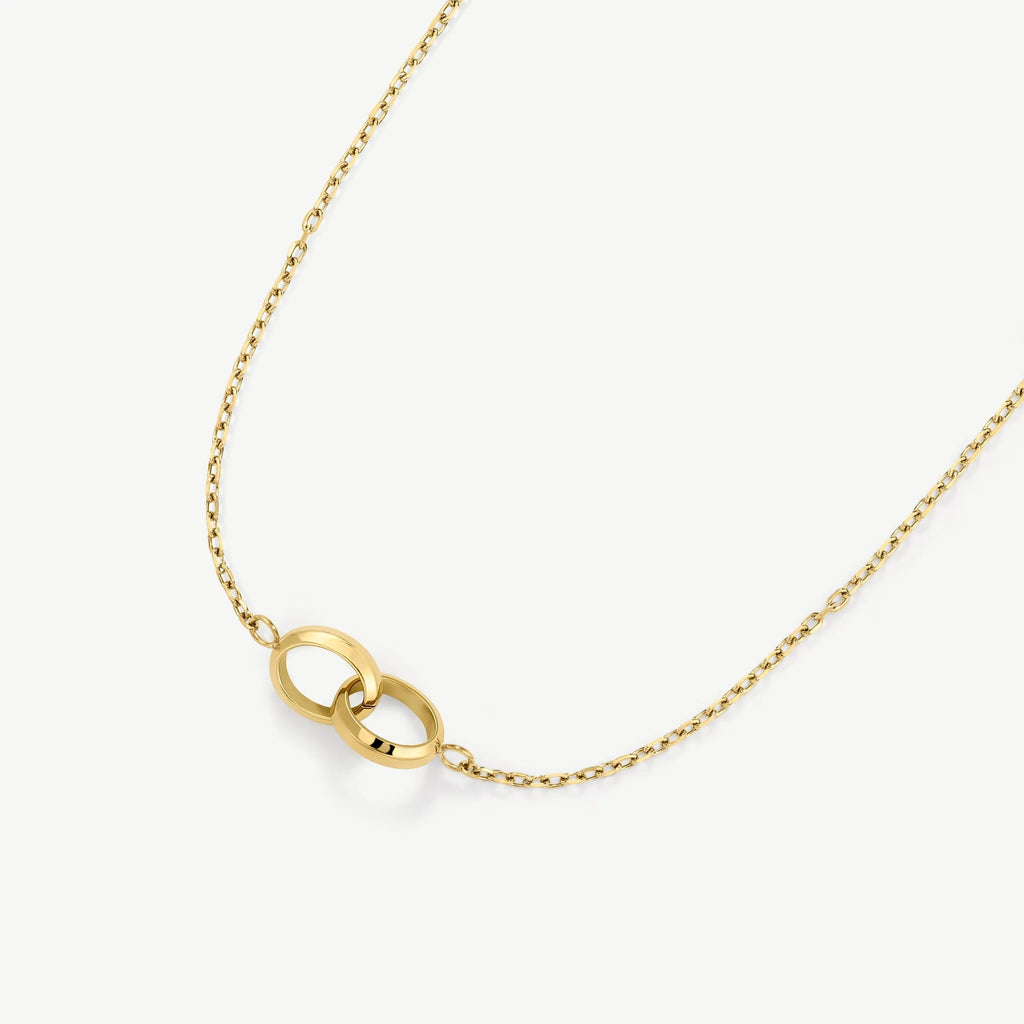 Gold necklace with two interlocking circular rings on a fine chain