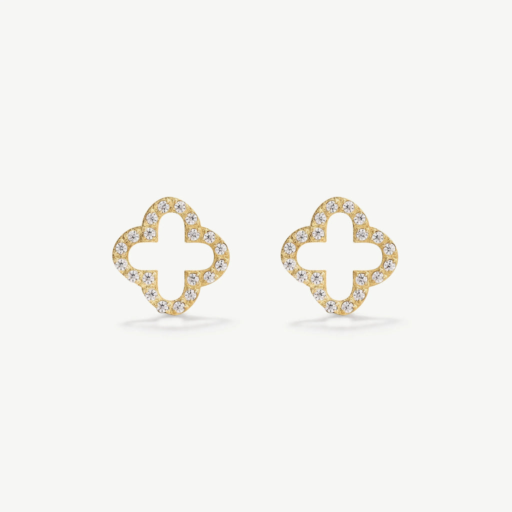 Gold stud earrings shaped like clover with clear rhinestones on white background