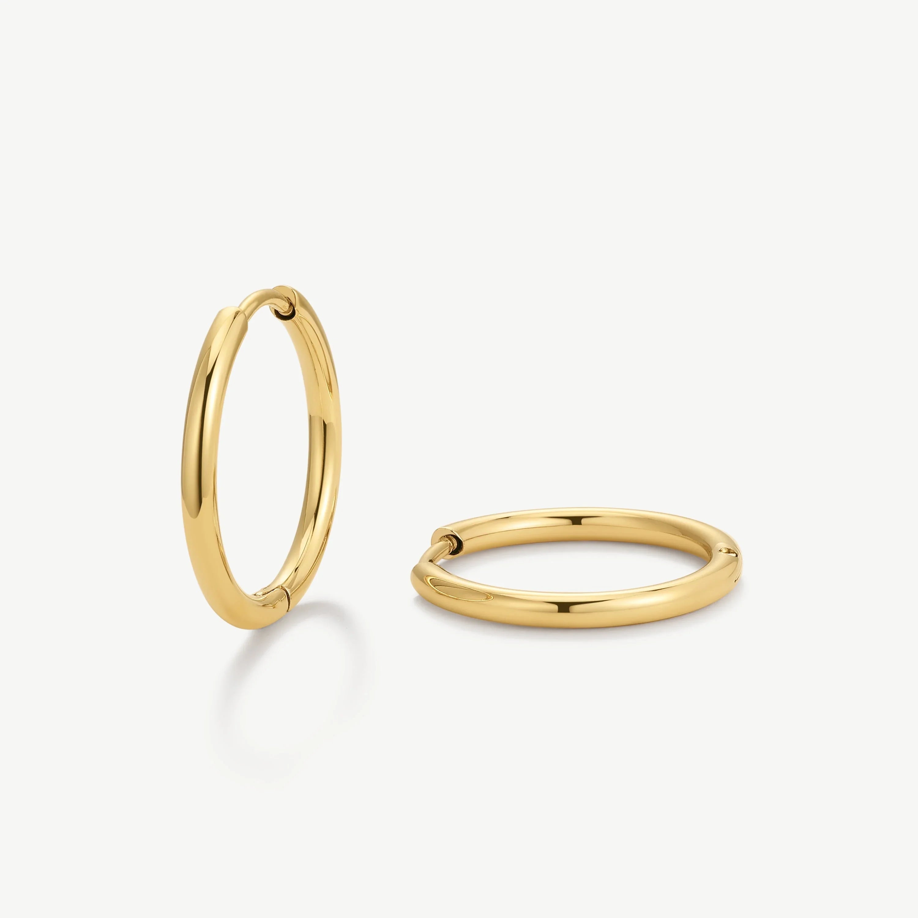Pair of polished gold hoop earrings on white background