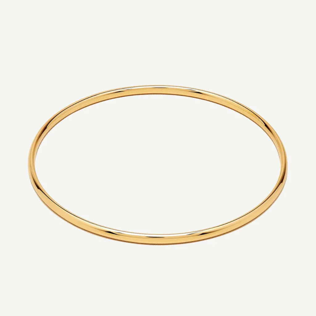 Thin polished gold bangle bracelet on white background