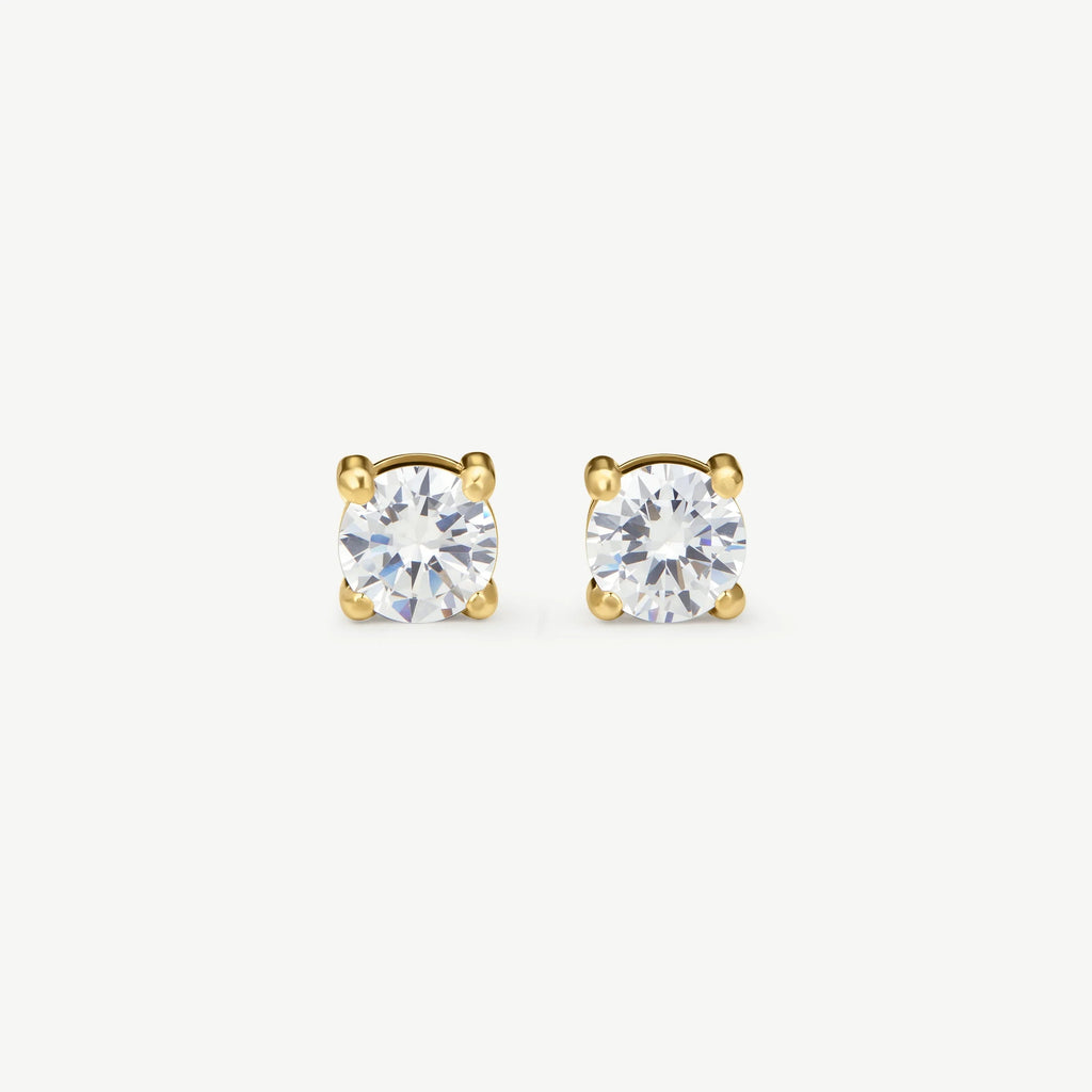 Pair of round-cut diamond stud earrings set in four-prong gold settings on white background