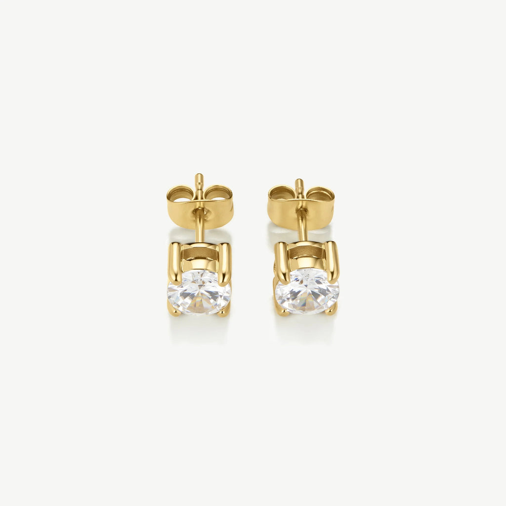 Pair of gold stud earrings with round clear gemstones on white background