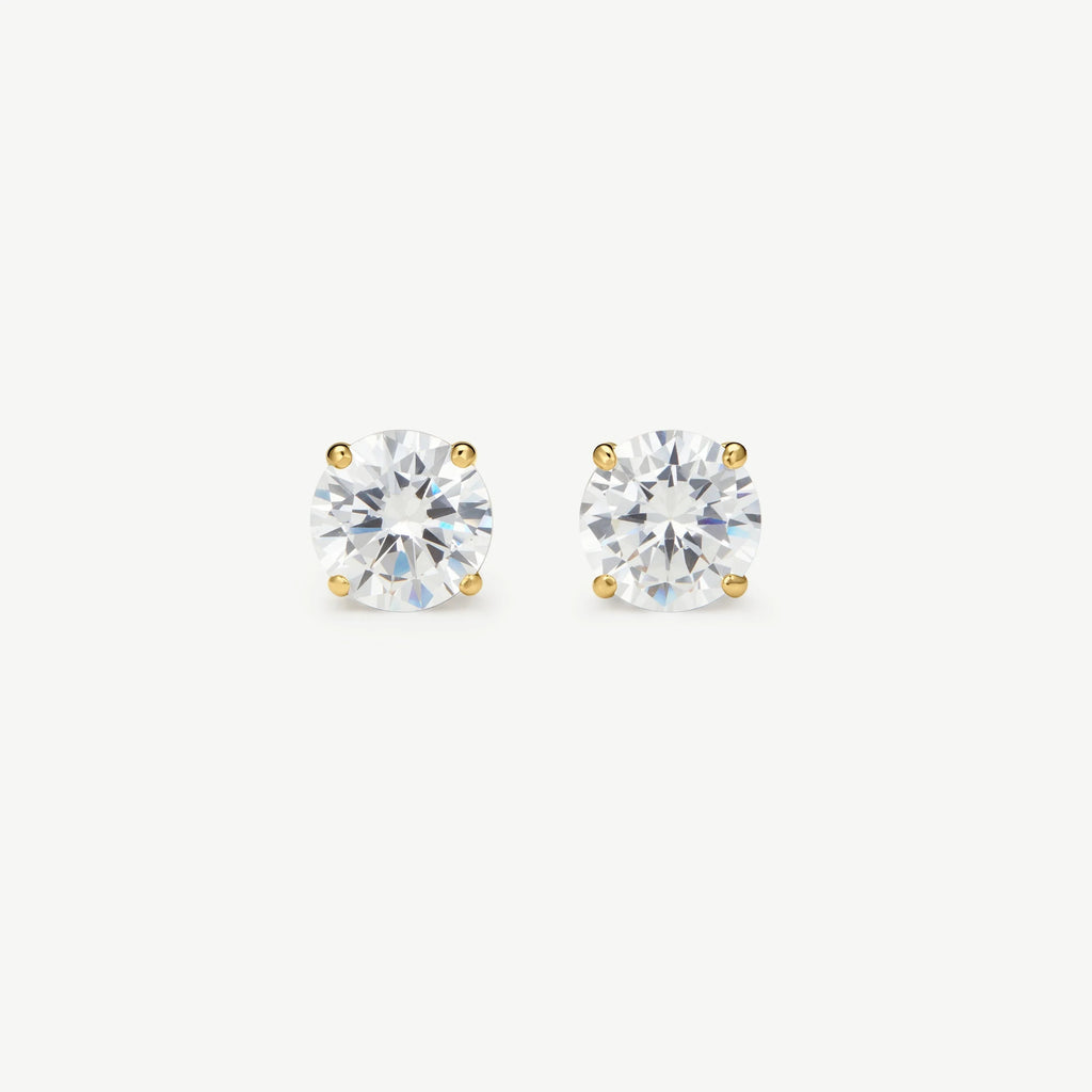 Pair of round clear diamond stud earrings set in four-prong yellow gold on white background