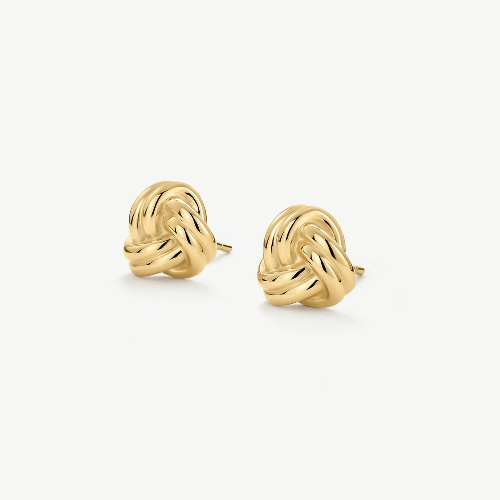 Pair of polished gold knot stud earrings on white background
