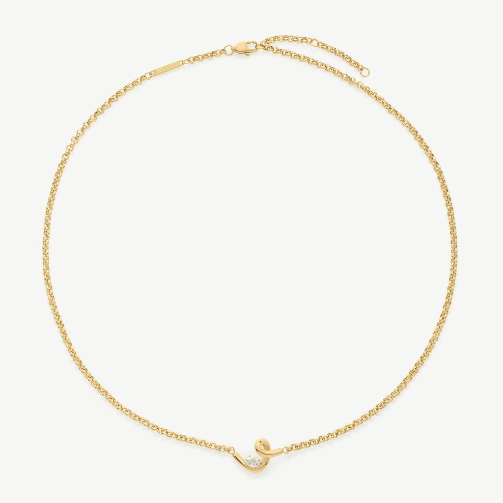 Elegant yellow gold chain bracelet with a small curved pendant and a clear round gemstone