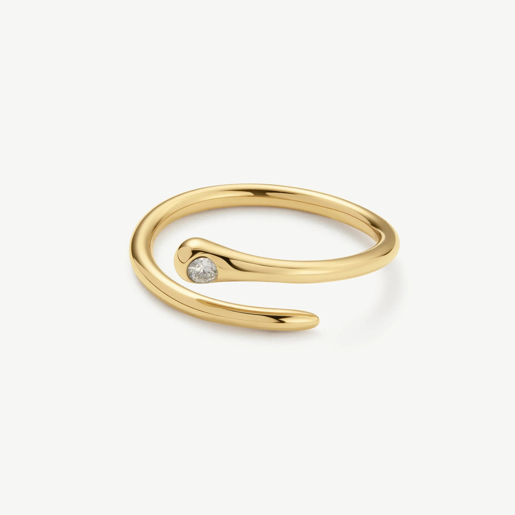 Minimalist open gold ring with a single small diamond set on one end on white background